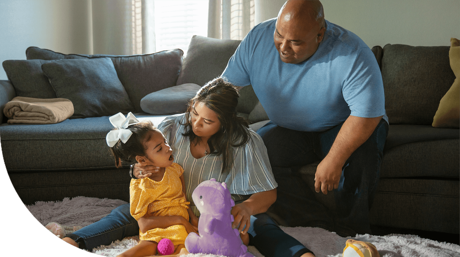 Gigi playing with a stuffed dinosaur with her family