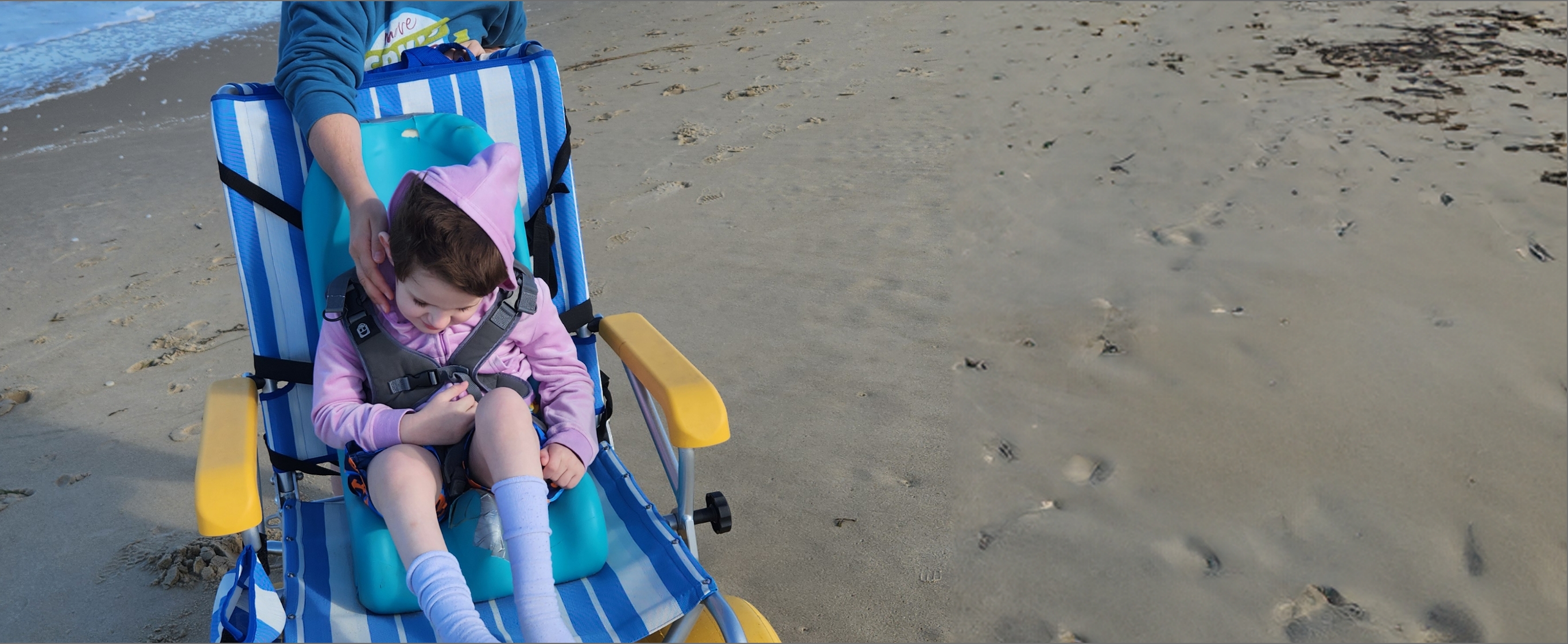 Lina sits in a chair on the beach