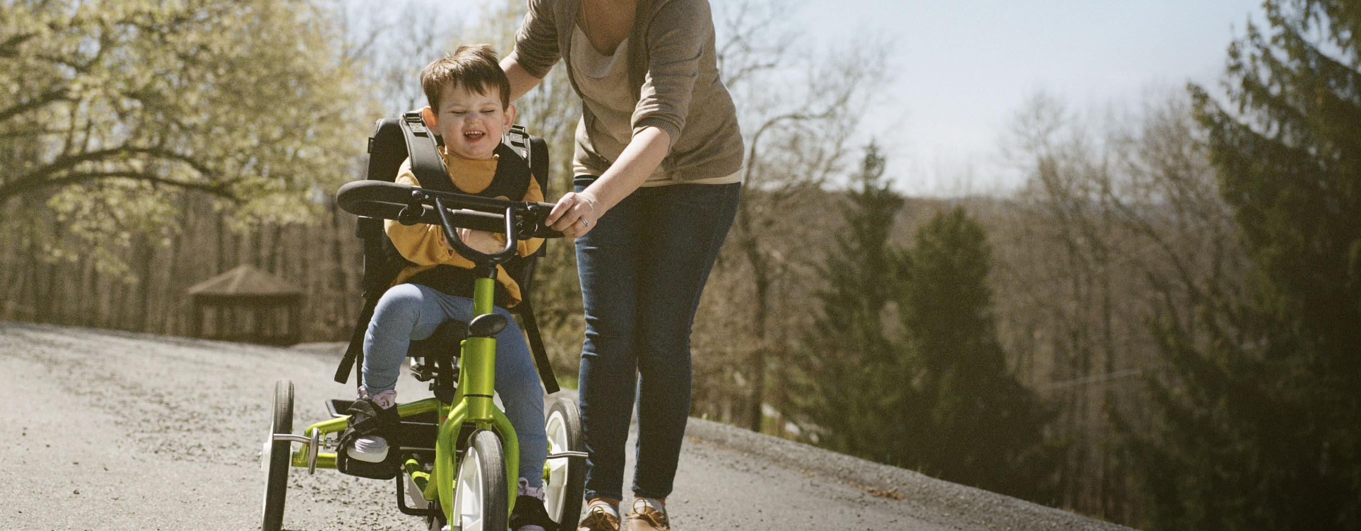 Diana steadies Lina as she rides a tricycle